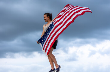 A girl with an American flag against the sky copy space.