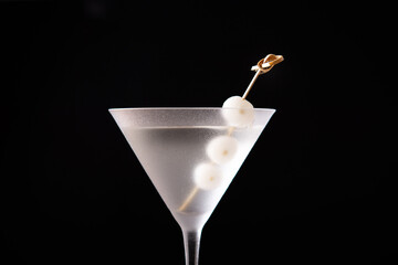 Gibson martini cocktail with onions on black background