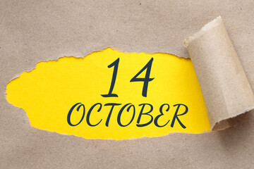 october 14. 14th day of the month, calendar date.Hole in paper with edges torn off. Yellow background is visible through ragged hole.Autumn month, day of the year concept