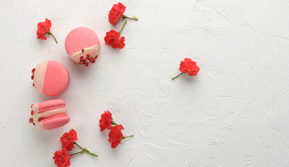 baked red strawberry macarons and rosebuds on a white table, gourmet almond flour dessert, close up