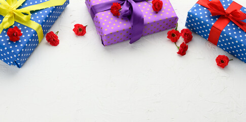boxes are packed in holiday paper with polka dots and tied with a silk ribbon on a background, birthday gift, surprise