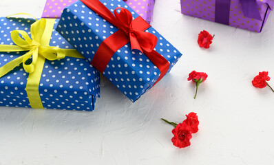 boxes are packed in holiday paper with polka dots and tied with a silk ribbon on a background,...