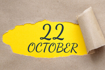 october 22. 22th day of the month, calendar date.Hole in paper with edges torn off. Yellow background is visible through ragged hole.Autumn month, day of the year concept