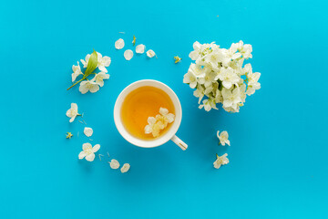 Obraz na płótnie Canvas Tea in a cup with jasmine flowers. Herbal tea top view