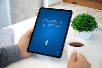 male hands hold computer tablet upright with app personal assistant
