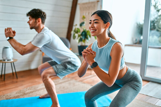 Young couple doing sports at home - Powered by Adobe