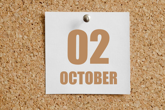 october 02. 02th day of the month, calendar date.White calendar sheet attached to brown cork board.Autumn month, day of the year concept