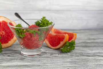 Summer salad with grapefruit on a light background with herbs.
