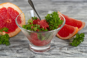 Summer salad with grapefruit on a light background with herbs.