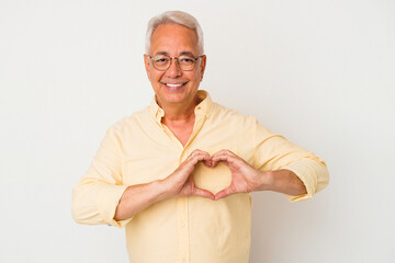 Senior american man isolated on white background smiling and showing a heart shape with hands.