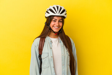 Young student caucasian woman wearing a bike helmet isolated on yellow background happy, smiling and cheerful.