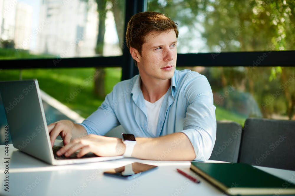 Poster pensive male copywriter with digital netbook device thoughtful looking away while working remotely i