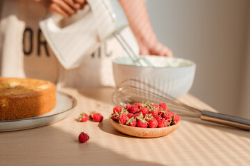 Kitchen mixer whips cream to make sponge cake or red velvet cake.