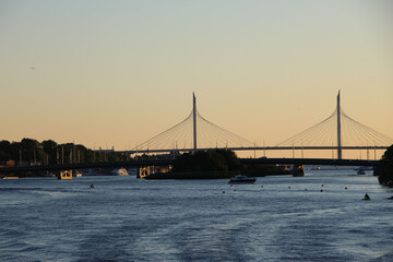 View of the riverbed and cable-stayed bridge on the horizon against the background of sunset