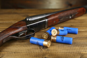 hunting rifles and cartridges are on wooden background, studio photo shot. hunter guns and bullets close up