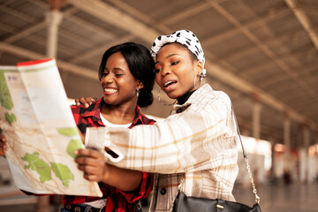 Beautiful girls looking for direction in the city. Young girlfriends travel together.