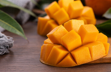 Mango. Fresh mango fruit with leaves over dark wooden table background.