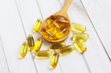 Fish oil capsules on wooden background and texture, Fish oil capsule placed on a wooden spoon, spot...