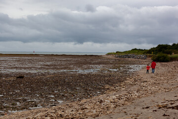 Une petite fille et sa grand-mère se promènent à la plage à marée basse à Penvins Bretagne France