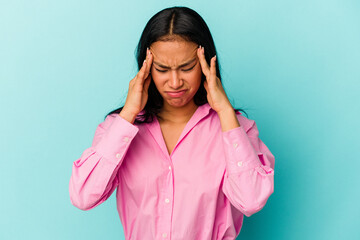 Young Venezuelan woman isolated on blue background having a head ache, touching front of the face.