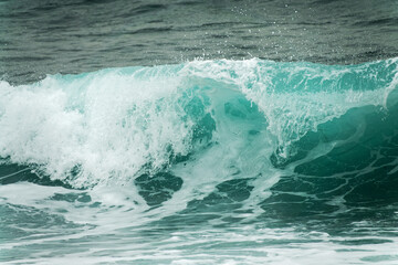 Close up of a wave. Blue clear water splash, ocean background.