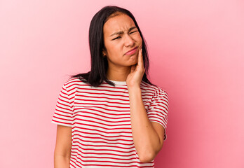 Young Venezuelan woman isolated on pink background having a strong teeth pain, molar ache.