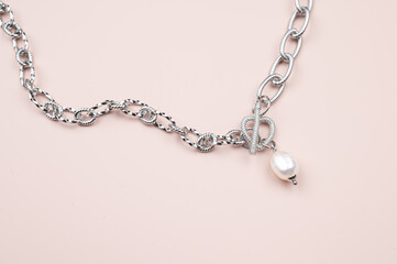 Silver chain with white baroque pearl pendant on pastel pink background