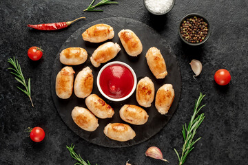 small grilled sausages on a stone background