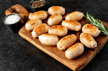 small grilled sausages on a stone background