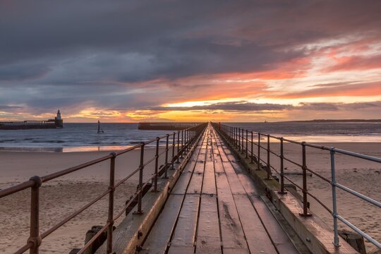 A glorious morning at Blyth beach, with a beautiful sunrise over the old wooden Pier stretching out to the North Sea © Paul Jackson