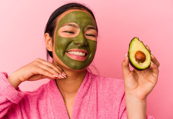 Young venezuelan woman wearing a facial mask isolated on pink background
