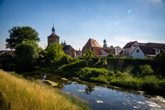 Seehausen in der Altmark, Sachsen-Anhalt, Deutschland. Der Fluss Aland flie&szlig;t vorbei an der Alzkirche und dem Beuster Tor im Sommer. Hinten ist die Kirche St. Petri zu sehen.