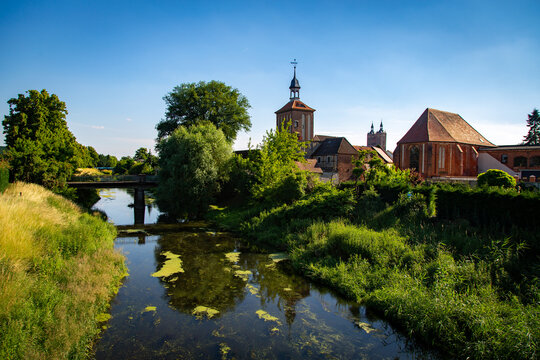 Seehausen in der Altmark, Sachsen-Anhalt, Deutschland. Der Fluss Aland flie&szlig;t vorbei an der Alzkirche und dem Beuster Tor im Sommer. Hinten ist die Kirche St. Petri zu sehen.