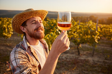 Winemaker with glass of wine in vineyard