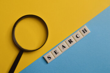 Magnifying glass and square letters with text SEARCH