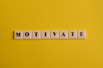 Square letters with text MOTIVATE isolated on yellow background