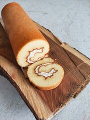 Kue Bolu Gulung or Bolu Roll Cake With Chocolate Inside on Wooden Board. Cake for Ramadhan and Idul Fitri, The Great Islamic Day.