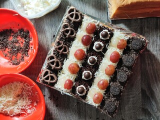 Bolu Potong Cake with Chocolate and Grapes on Top. 