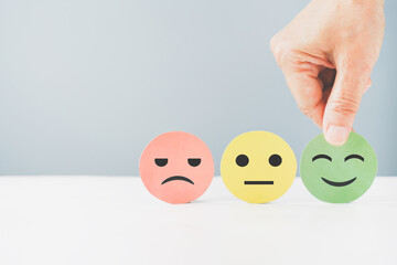 hand choose green paper cut, happy smiling face for mental health assessment ,positive thinking, world mental health day ,customer review, experience, satisfaction survey concept