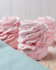 Marshmallow - zephyr on a dark background. Pink fluffy marshmallow with strawberry taste over black.