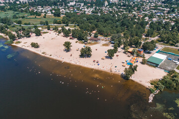 Aerial view of
city ​​Beach. People sunbathe and relax near the water. Summer swimming in a river or sea. Sunny day .