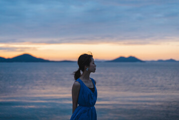 夕暮れの海にいる女性