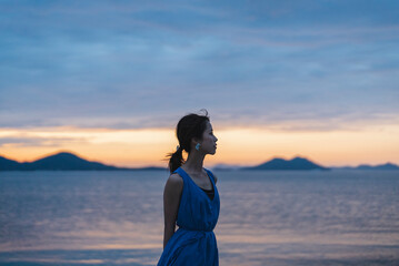 夕暮れの海にいる女性