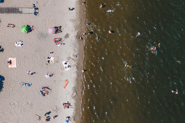 Fototapeta na wymiar Aerial view of city ​​Beach. People sunbathe and relax near the water. Summer swimming in a river or sea. Sunny day .