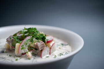 close up of russian traditional cold soup okroshka in bowl on black background