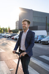 A vertical shoot of a young man in a suit riding an electric scooter