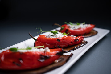 closeup of bulgarian peppers stuffed with cottage cheese on black background