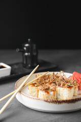 Tuna sushi in white dish served with soy and wasabi sauce, pickled ginger. Sushi set with tuna shavings on top.