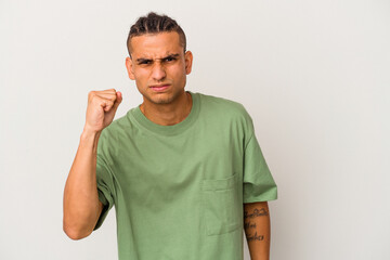 Young venezuelan man isolated on white background showing fist to camera, aggressive facial...