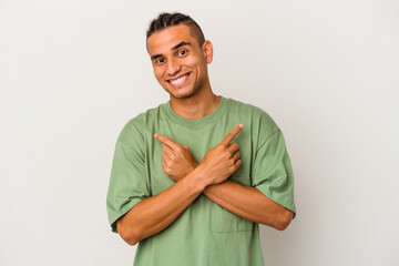 Young venezuelan man isolated on white background points sideways, is trying to choose between two...